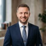 Портрет уверенного бизнесмена компании Alpha-Hp на нейтральном фоне для сайта по проектированию домов